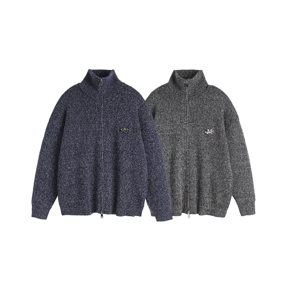 Two zip-neck ribbed sweaters shown side by side in navy and charcoal, each with a raised collar and chest emblem.