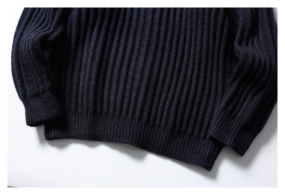 Cropped flat lay of a dark navy rib-knit sweater showing its torso, long sleeves, and ribbed hem.