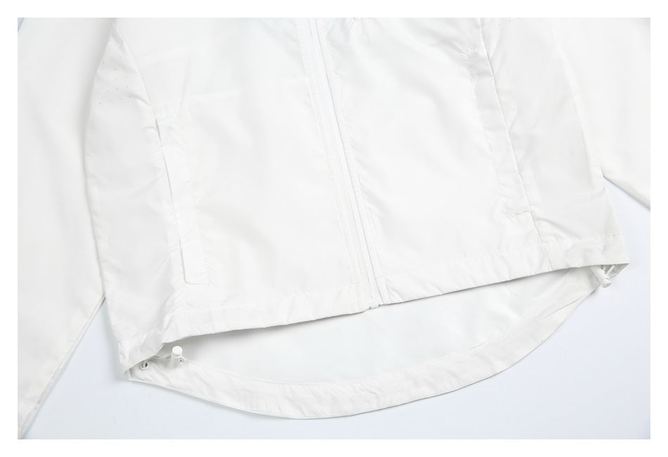 Close-up of the white windbreaker’s front zipper, curved hem, and adjustable drawcords.