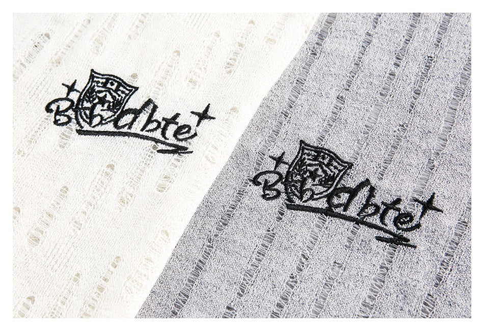 Black embroidered graphic on white and gray open-knit fabric.