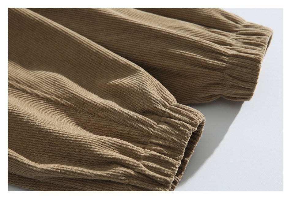 Close-up of two gathered elastic cuffs on a tan corduroy garment.