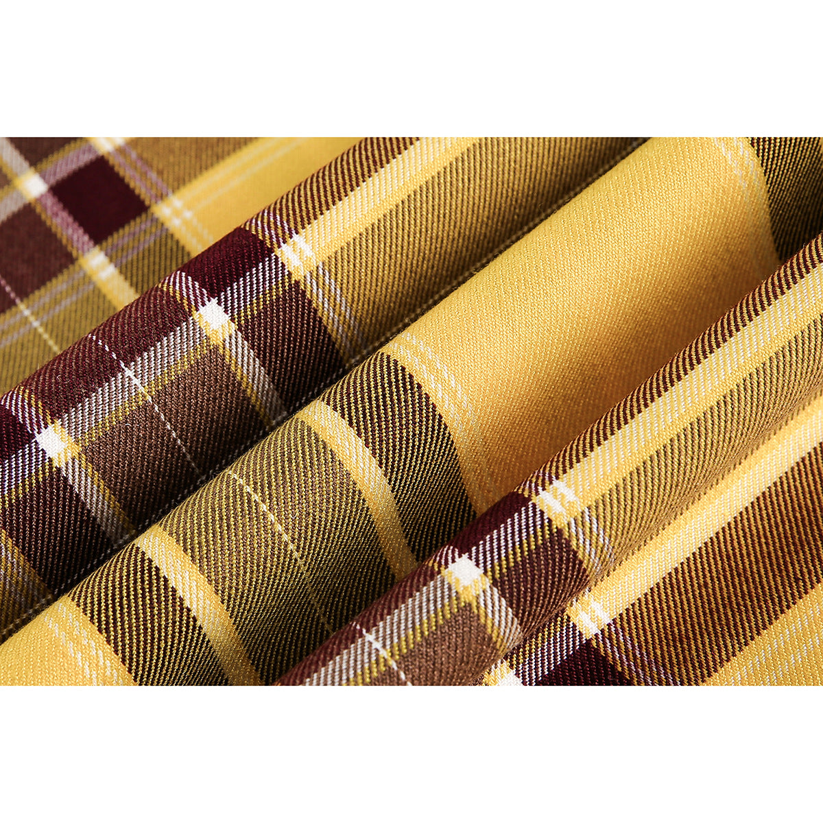 Macro view of mustard yellow, brown and burgundy plaid fabric with a fine woven texture.