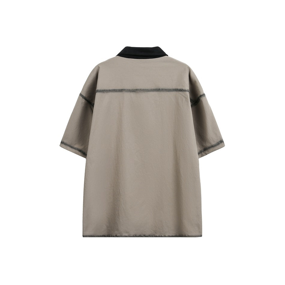 Back view of khaki short-sleeve shirt with black collar and horizontal yoke seam with faded edge detail