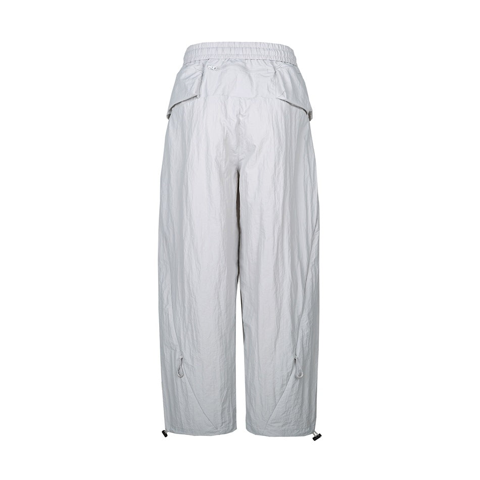 Back view of light gray relaxed-fit pants with an elastic waistband, flap pockets, and adjustable hems.