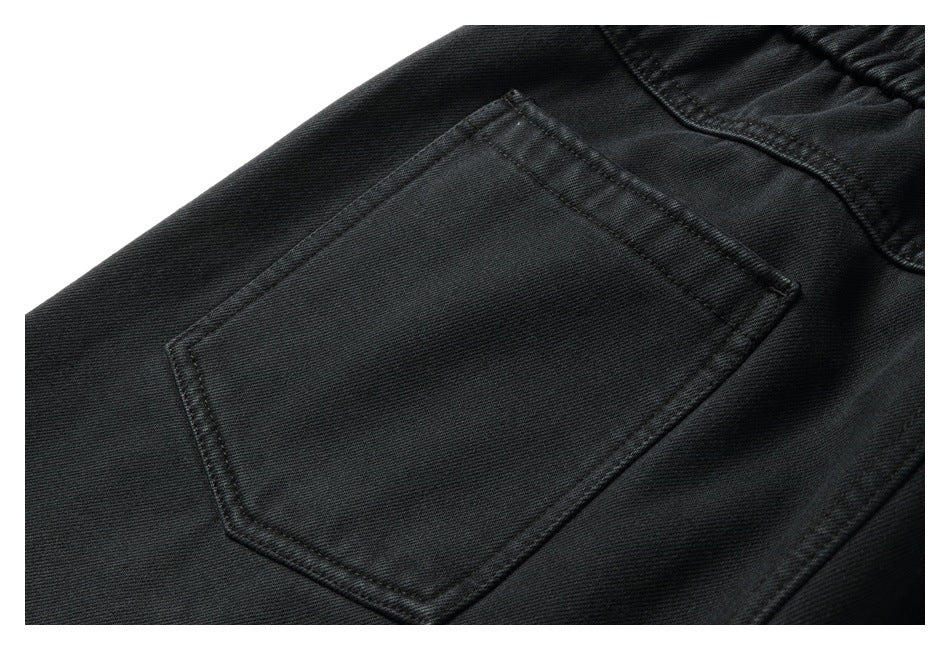 Close-up of black pants showing a stitched rear pocket and waistband.