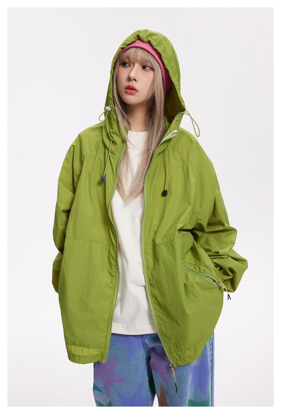 Model wearing an open lime-green hooded jacket with drawcords and zip pockets, shown from the front.