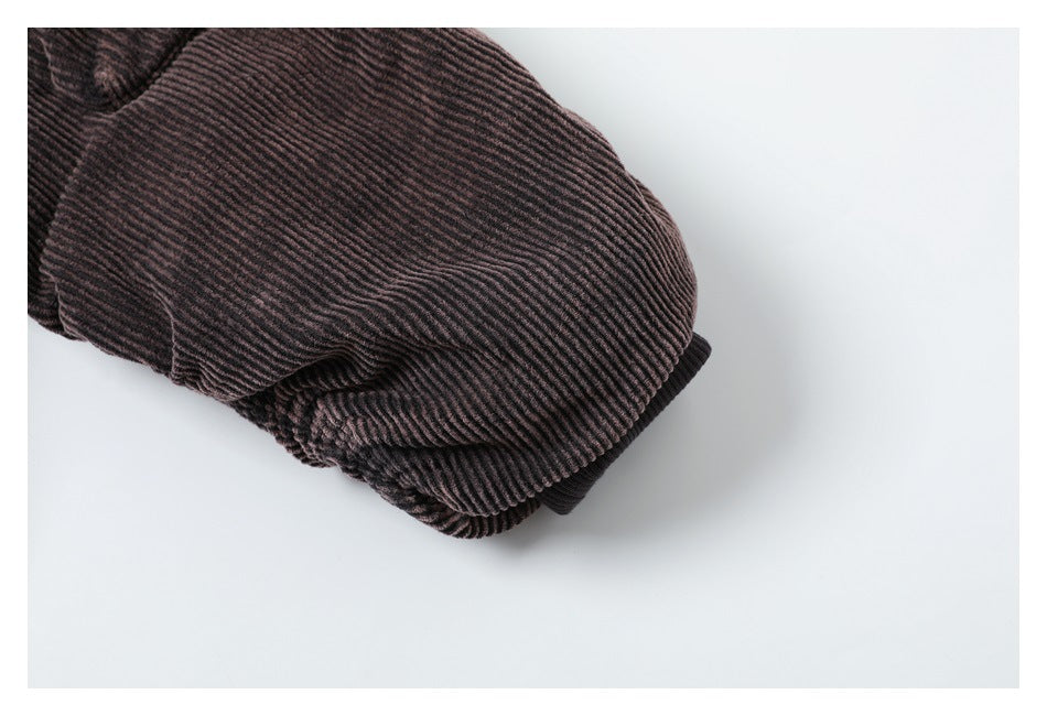 Close-up of a dark ribbed jacket sleeve ending in a gathered cuff.
