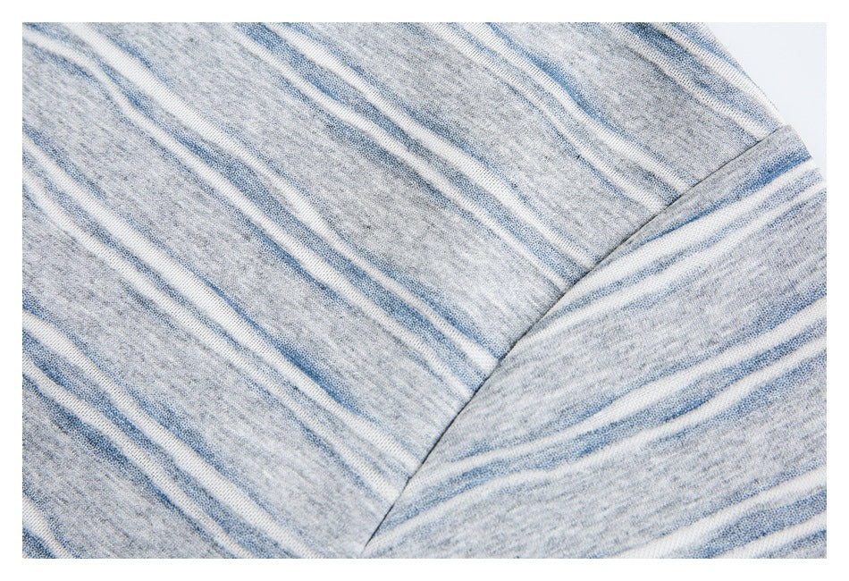 Close-up of striped gray knit fabric showing a curved panel seam and garment edge.