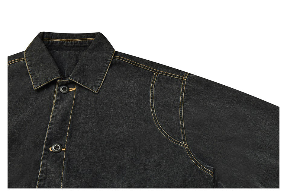 Partial front view of a charcoal denim jacket showing its collar, button placket and curved shoulder seam.