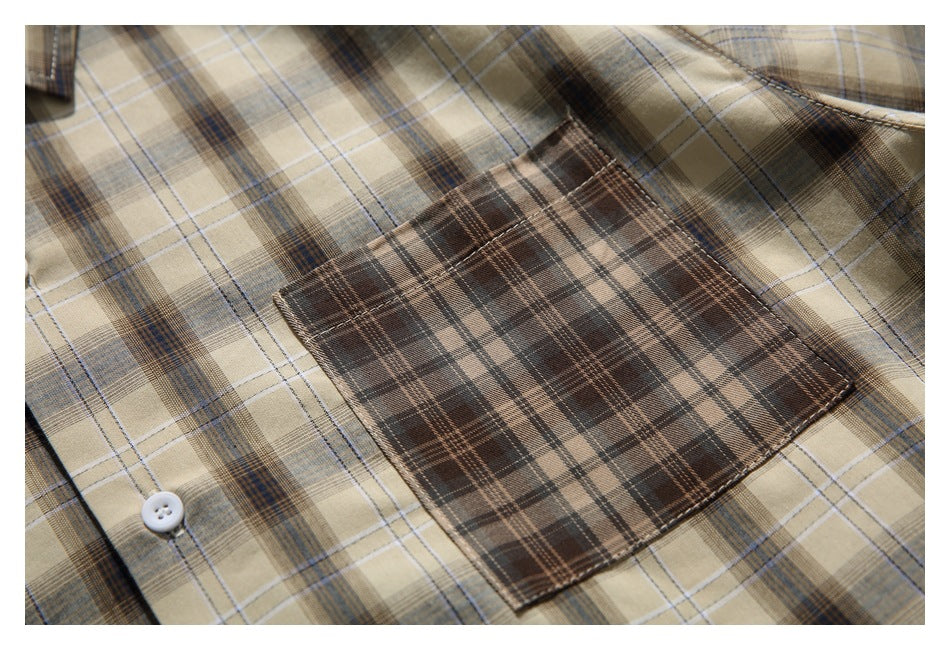 Close-up of a brown plaid chest pocket on a beige checked shirt, with a white button nearby.
