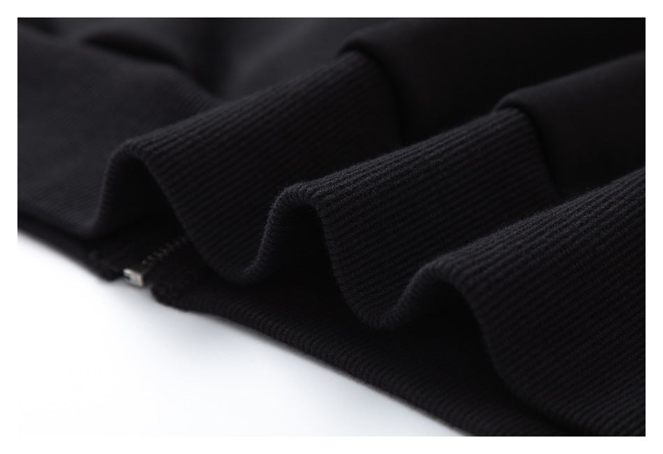 Close-up of black ribbed garment trim with a small zipper visible between folded sections.