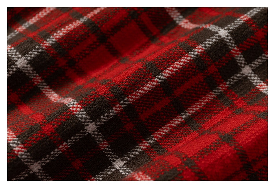 Macro view of the red, black, and white plaid fabric weave.