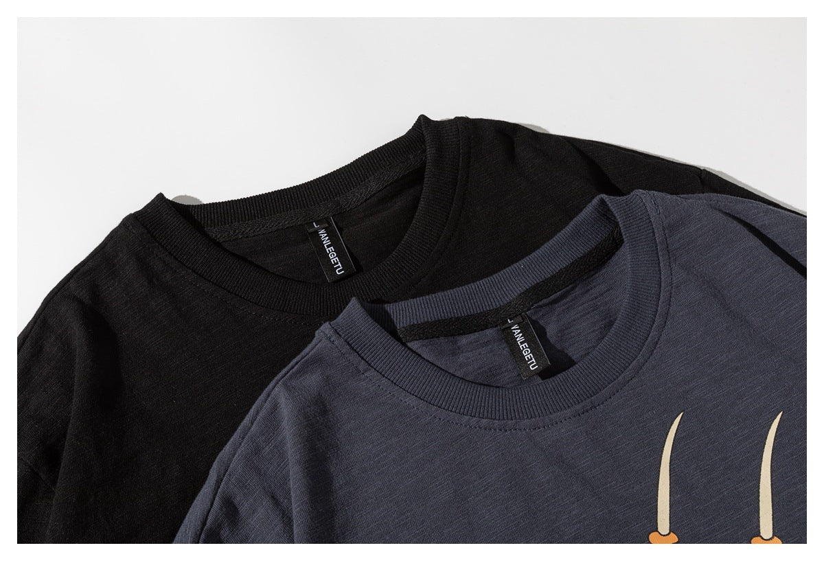 Close-up of black and slate-blue crew-neck shirts with ribbed collars and small interior neck labels.