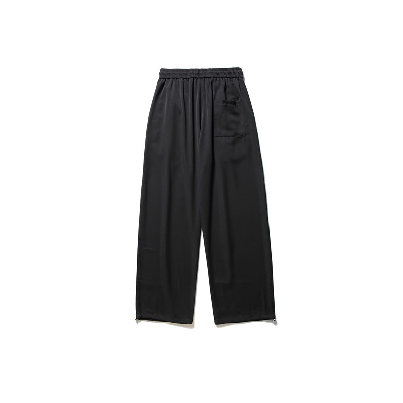Back view of black wide-leg pants with an elastic waistband and a single rear patch pocket.