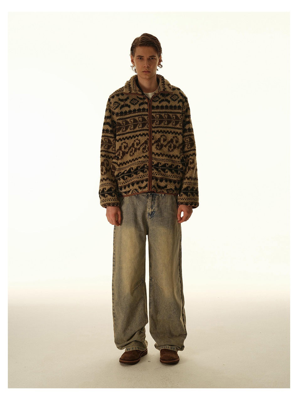 Full-length front view of a man in a brown and black patterned zip-front fleece jacket and loose faded jeans.