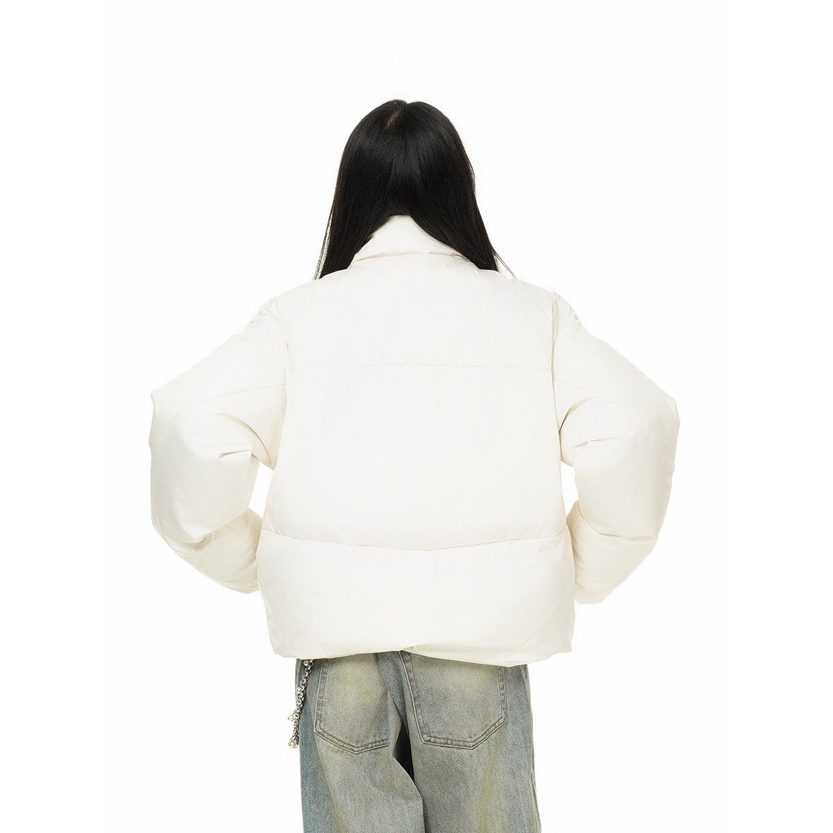 Rear view of a model wearing an ivory puffer jacket with horizontal seam panels and oversized sleeves.
