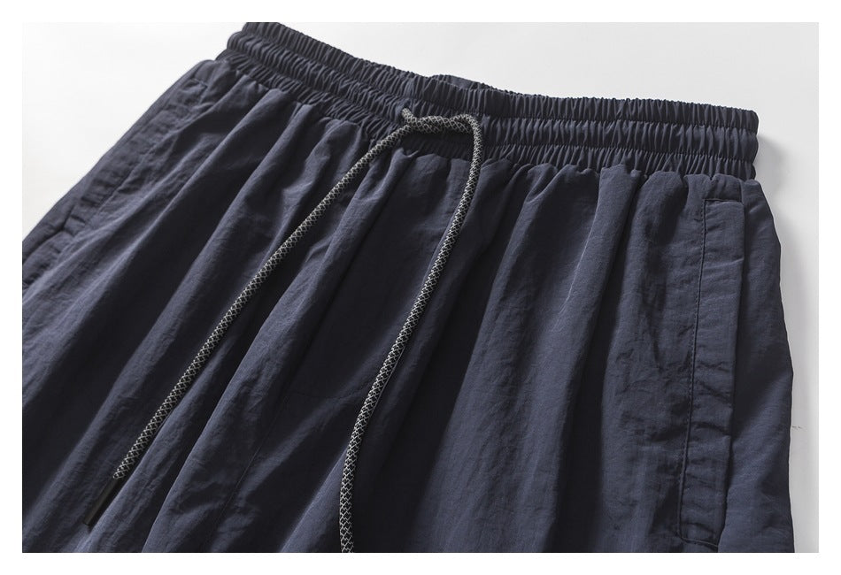 Close-up of the pants' elastic waistband, braided drawstring and side pocket.