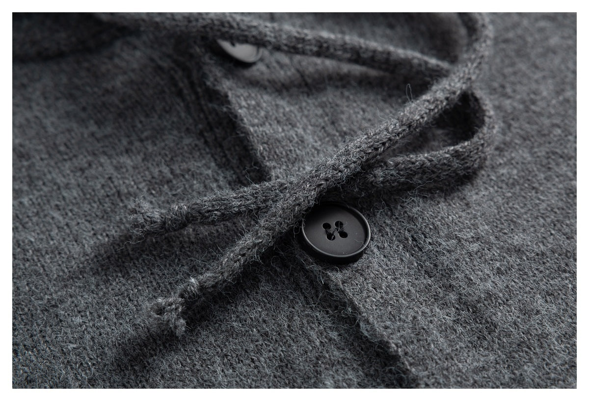 Close-up of a dark gray fuzzy knit garment showing a black button and layered button placket.