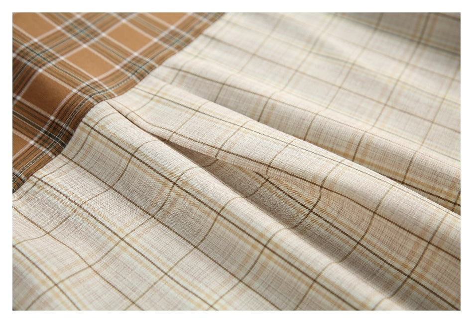 Close-up of the shirt's cream plaid fabric with a section of brown plaid at the edge.