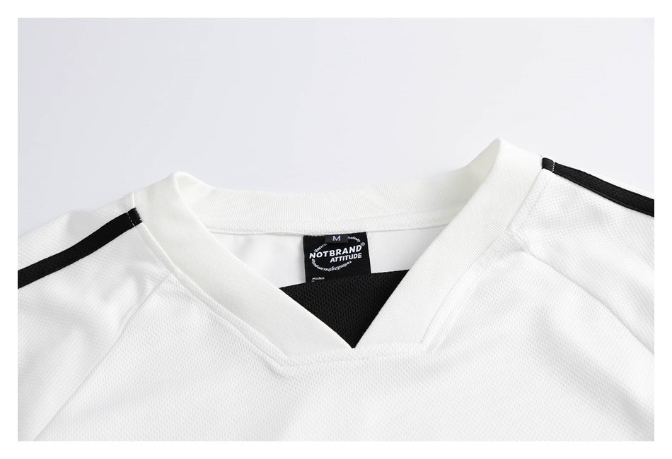 Close-up of a white V-neck jersey with black shoulder stripes and a black neck label.