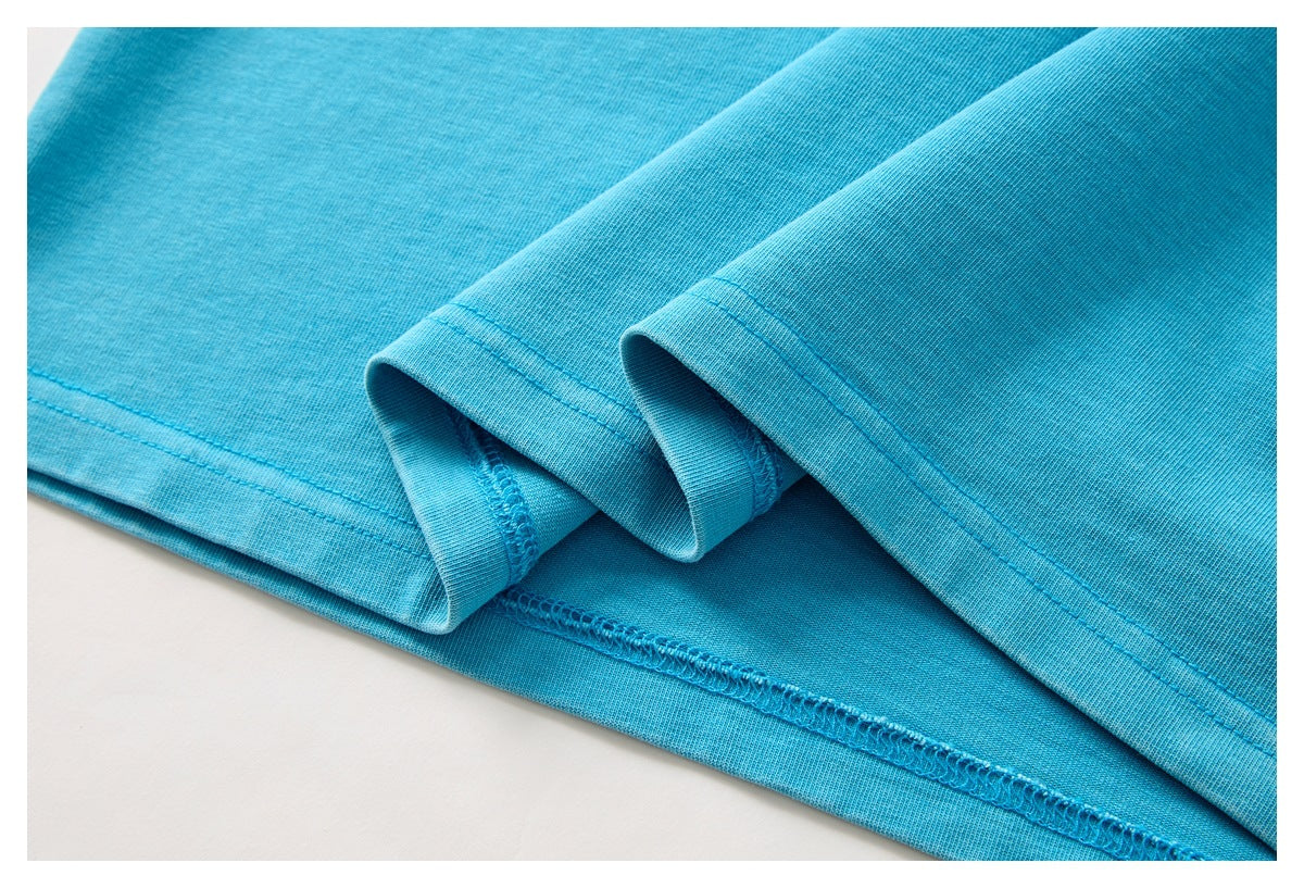 Close-up of the folded sleeve hems and stitching on a turquoise T-shirt.