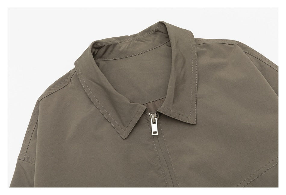 Close-up of a taupe jacket collar and front zipper with visible stitching.