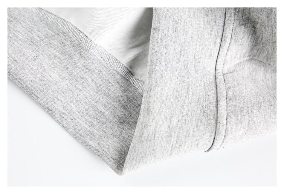 Close-up of stitching and folded fabric at the cuff or hem of a light gray heather hoodie.