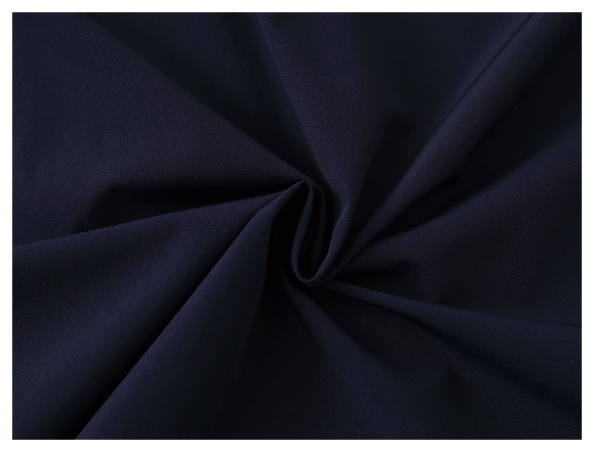 Close-up of plain dark navy fabric gathered into folds.