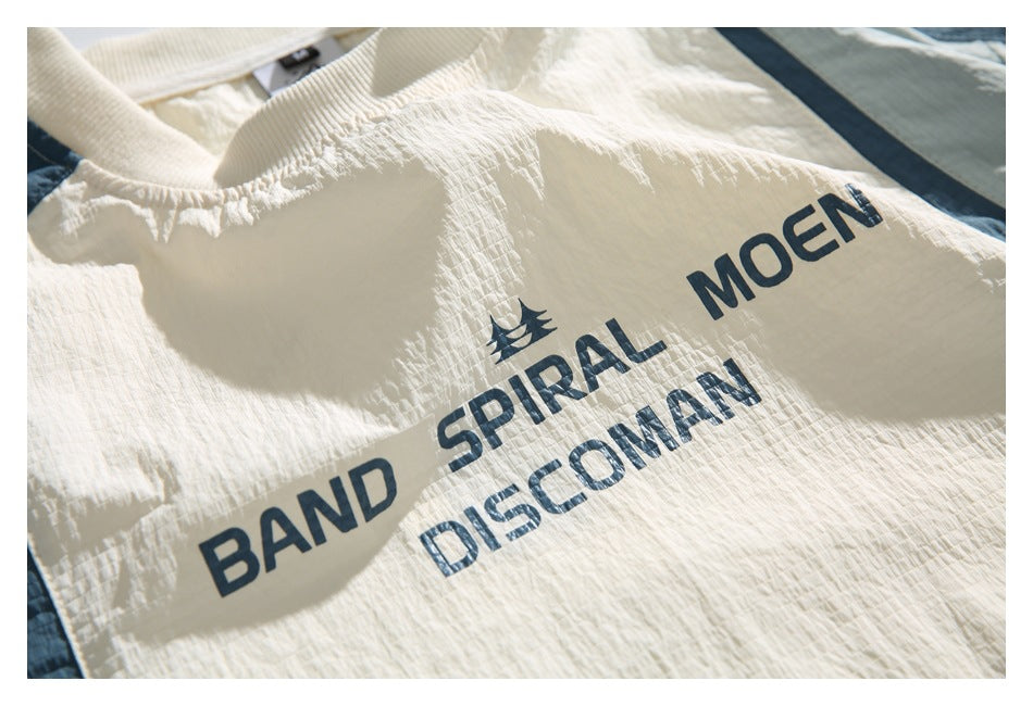 Close-up of dark blue lettering printed on the cream front of the shirt.