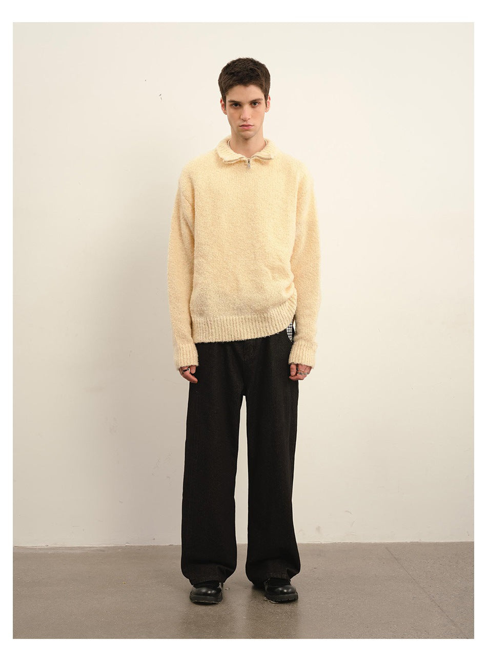 Front view of a man wearing a cream fuzzy knit quarter-zip sweater with black wide-leg pants.