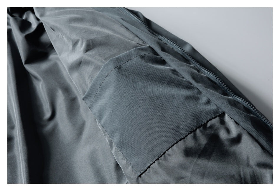 Close-up of the open slate-gray jacket interior, showing the lining, zipper, and a rectangular inner pocket.