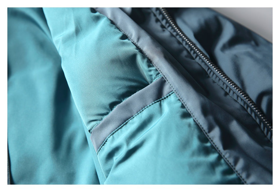 Close-up of blue jacket fabric, a stitched sleeve seam, and part of the front zipper.