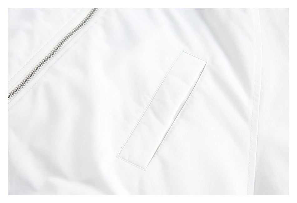 Close-up of a white jacket's diagonal zip and narrow angled pocket.