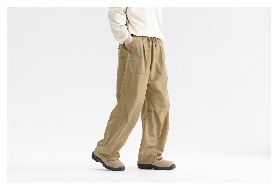 Model wearing loose khaki drawstring pants with a cream long-sleeve top, shown from waist to shoes.