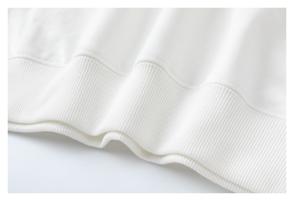 Close-up of the white sweatshirt’s wide ribbed hem.
