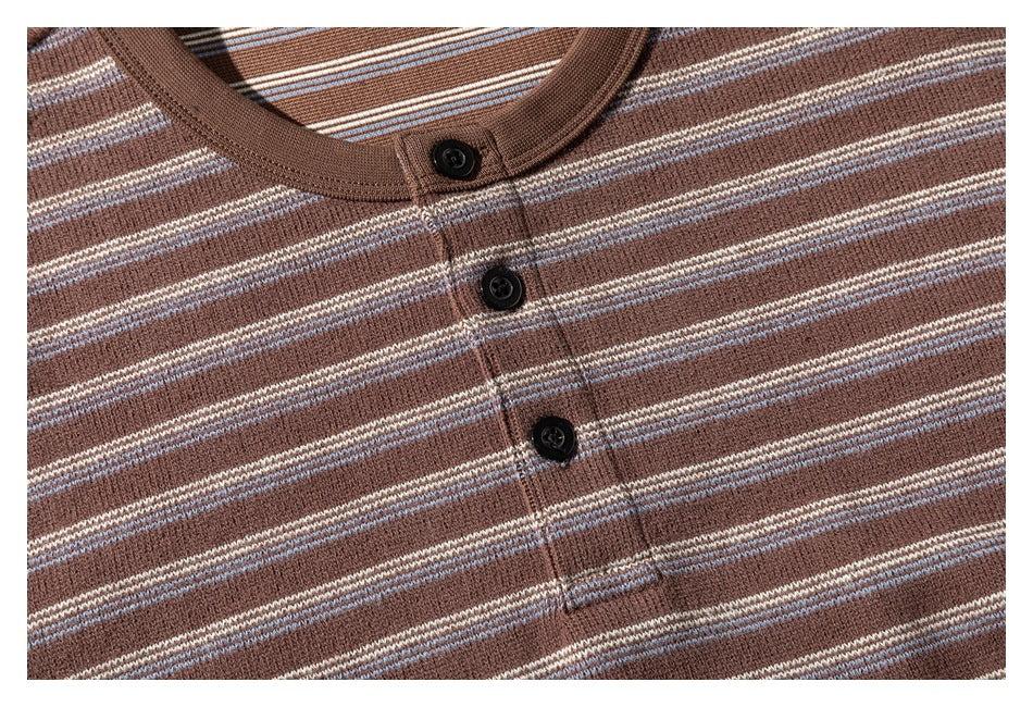 Close-up of the brown striped knit shirt's neckline and three black buttons.