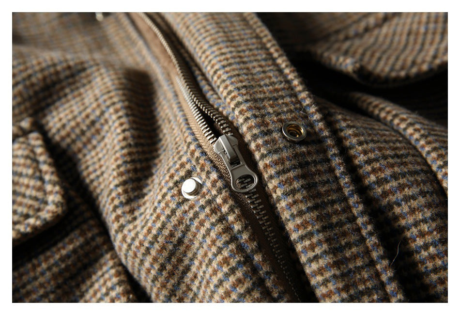 Close-up of the coat's front zipper, metal snap, and brown checked fabric.