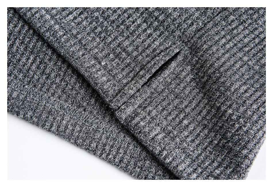 Close-up of a folded edge and seam on the charcoal gray textured knit garment.