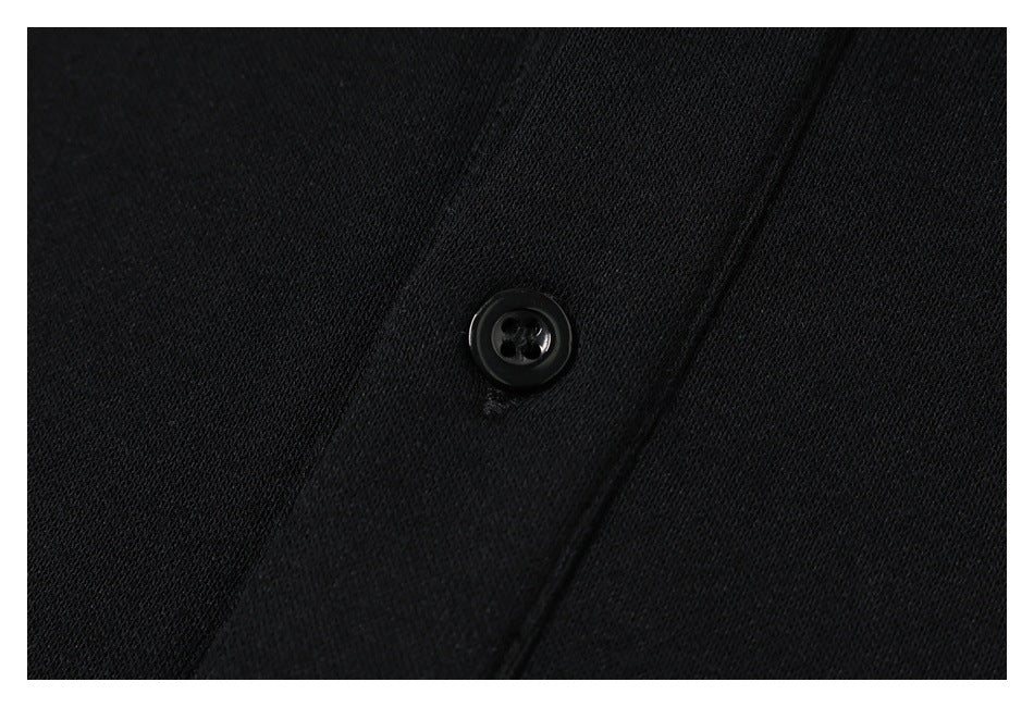 Close-up of a black four-hole button on the shirt's black placket.