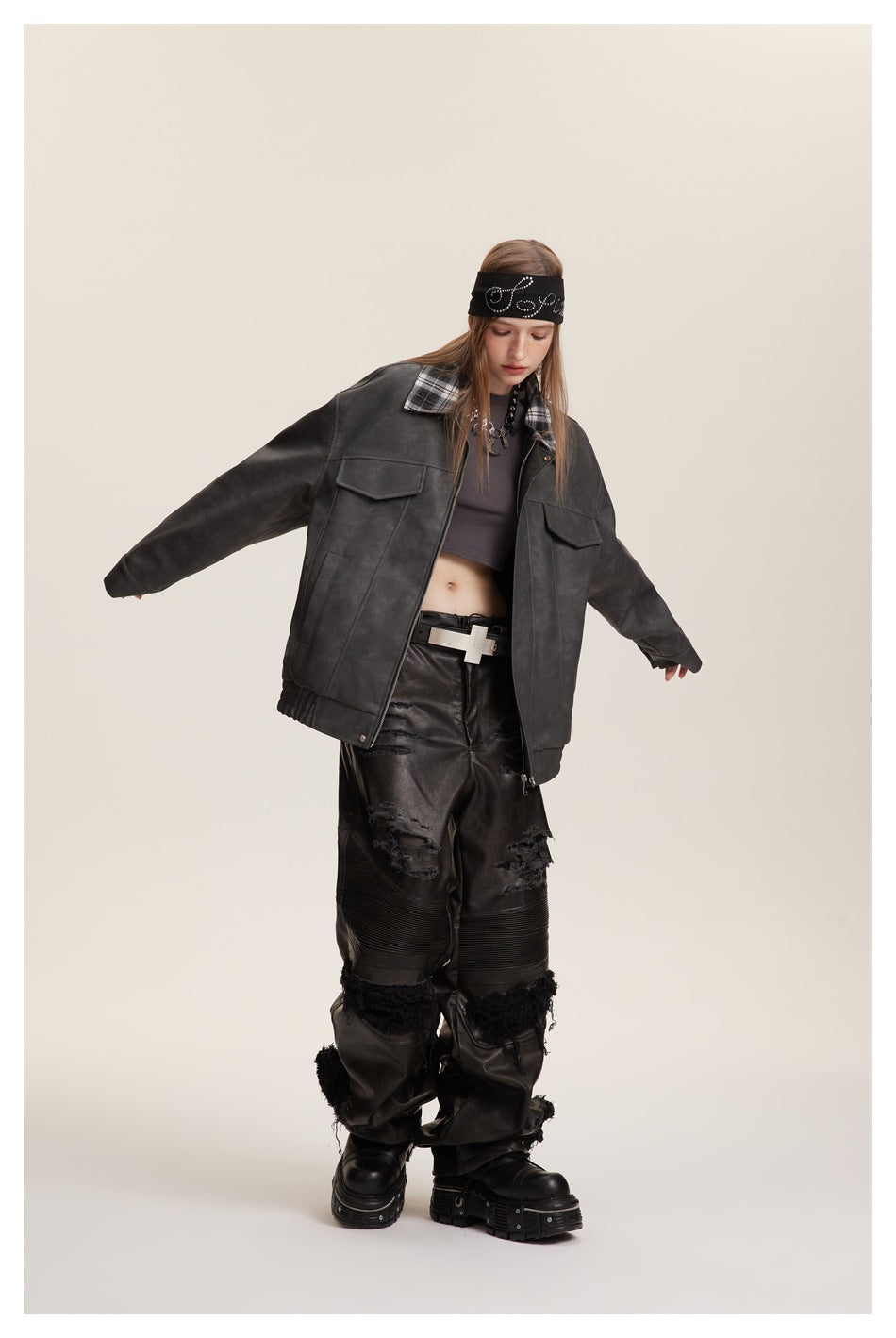 Model wearing an oversized charcoal jacket with a plaid collar and flap pockets, paired with distressed black pants.