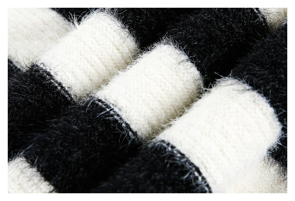Macro view of fuzzy black-and-ivory knit stripes showing the textured yarn and stitches.
