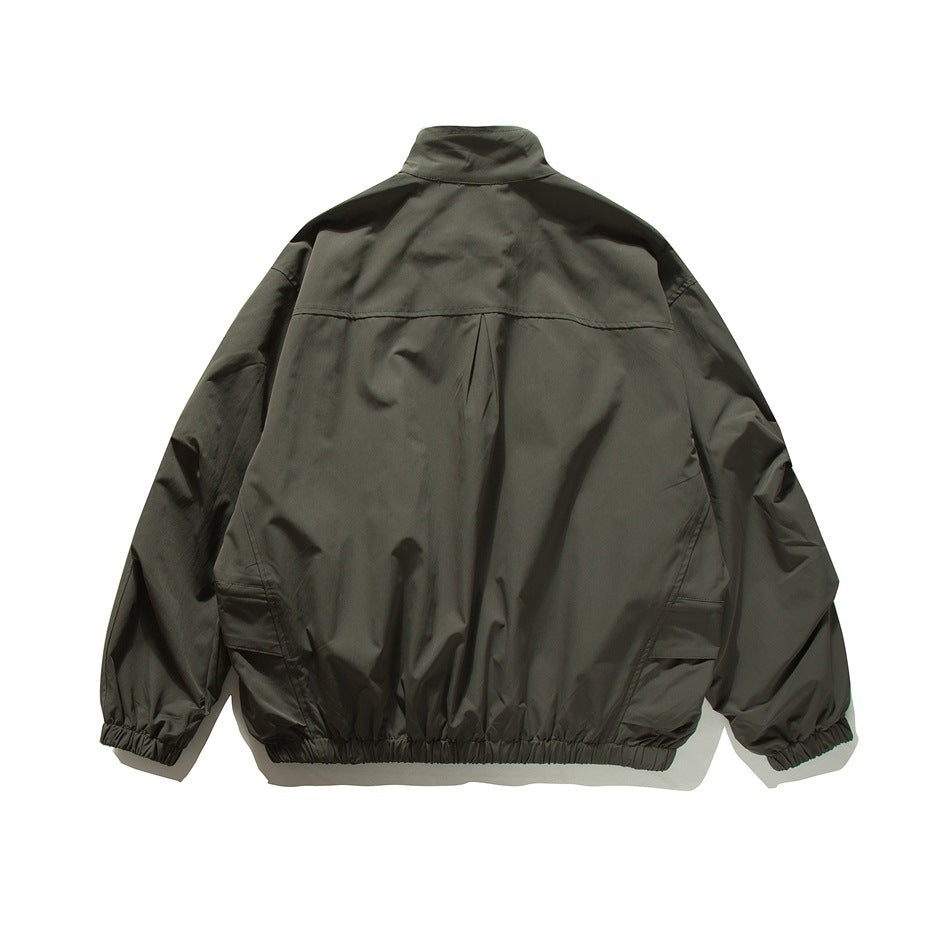 Back view of a dark olive-gray jacket with a stand collar, back yoke, and gathered cuffs and hem.