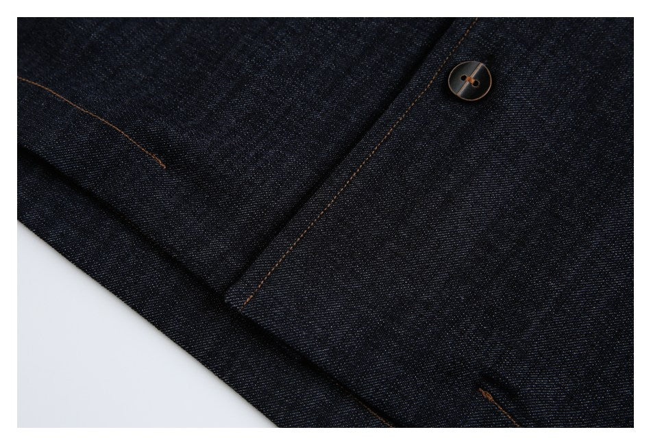 Close-up of dark denim showing a dark button, seam, and contrasting brown stitching.
