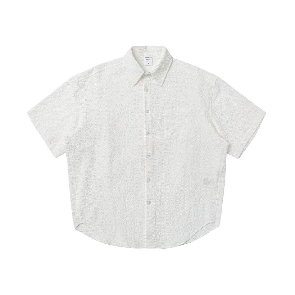 White textured short-sleeve button-up shirt with chest pocket, front view flat lay
