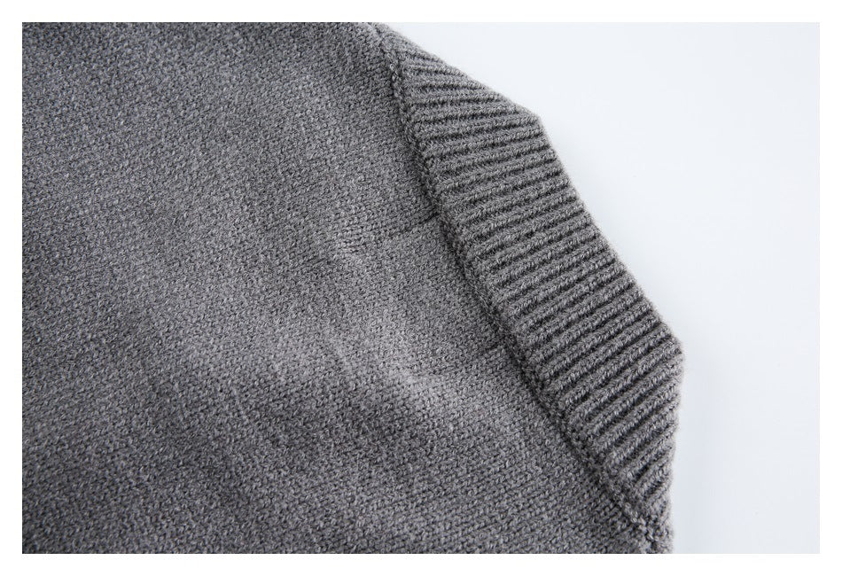 Close-up of gray knit garment with a ribbed edge and textured stitching.