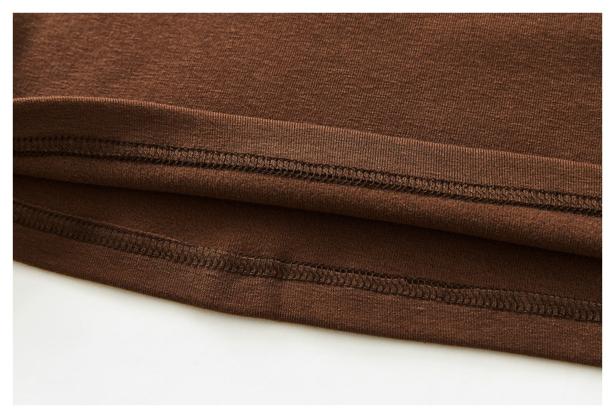 Close-up of the brown top's stitched hem and finished edge.