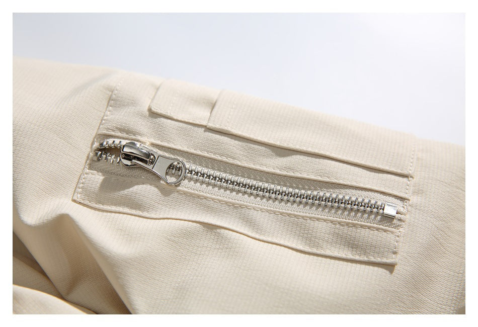 Close-up of a silver zipper pocket on the ivory jacket.