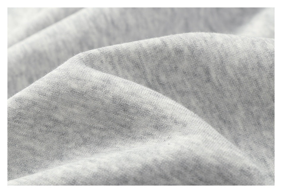 Close-up of light gray heathered knit fabric gathered into soft folds.