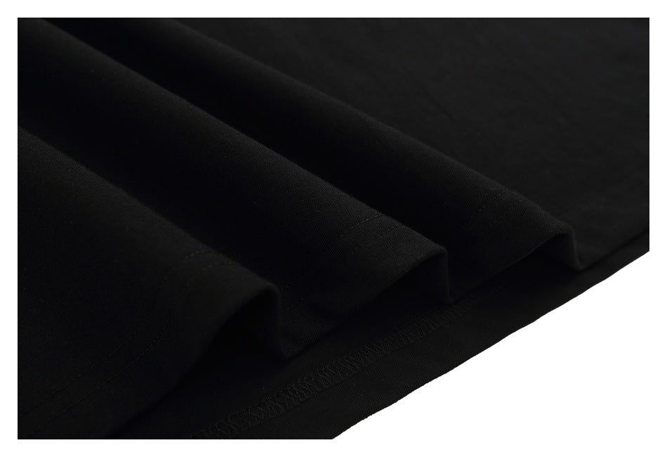 Close-up of the black T-shirt's folded hem with visible stitching.