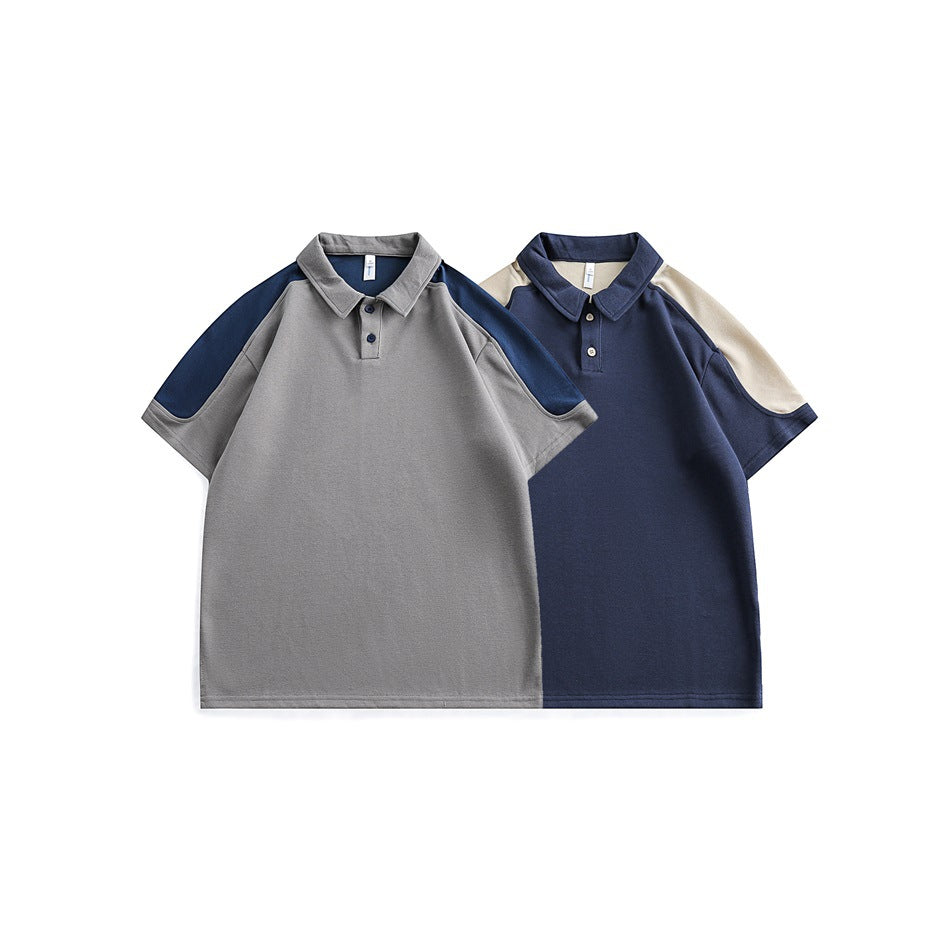 Two short-sleeve polo shirts shown from the front: gray with navy panels and navy with cream panels.